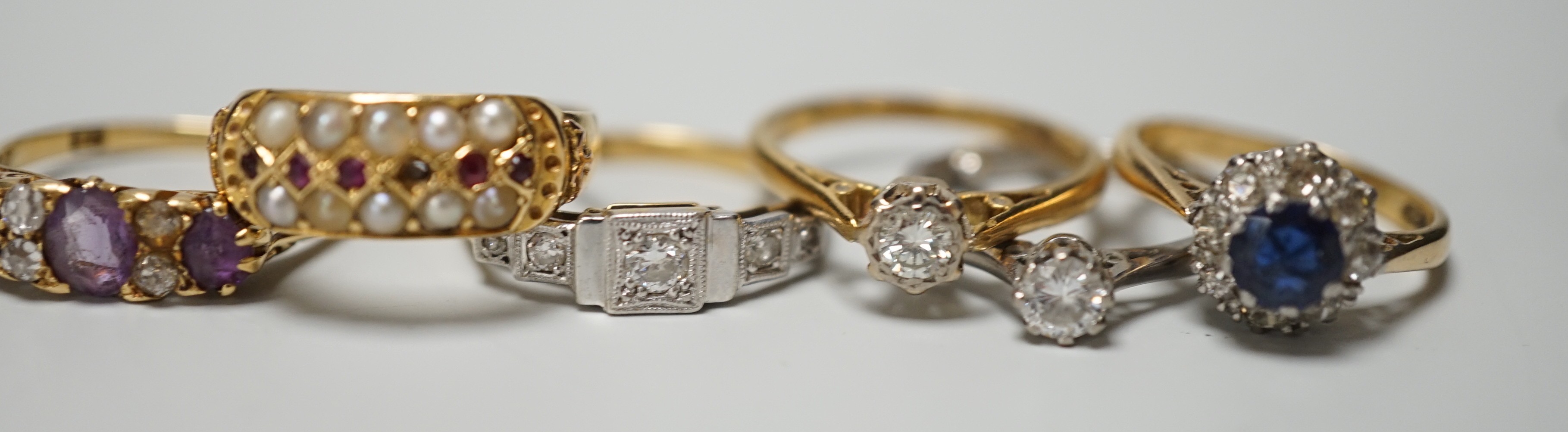 Five assorted 18ct and gem set rings, including 1920's millegrain diamond set, two solitaire diamond rings, sapphire and diamond cluster and amethyst and diamond half hoop (stone replaced and repair) and one other yellow